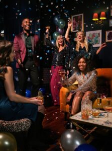 a group of people celebrating with confetti and balloons